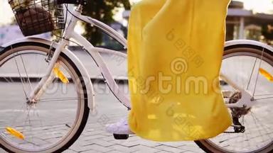 白色城市自行车`车轮旋转的特写镜头。 有铃铛，篮子和花的城市自行车。 无法辨认的妇女